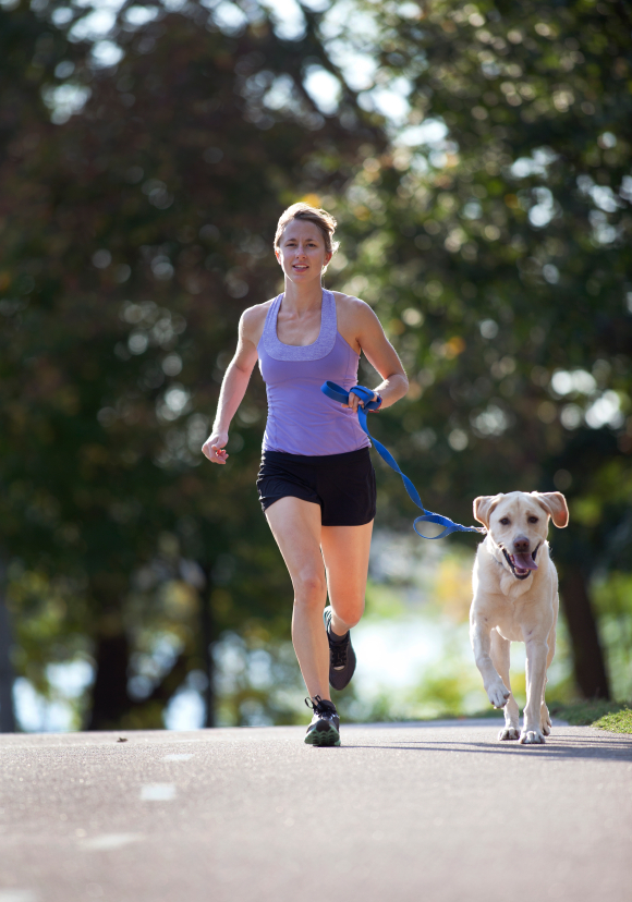 Un femme court avec son chien